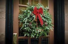 Evergreen wreath with red bow on apartment door