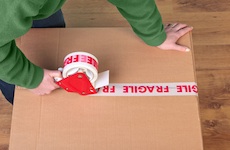 person taping up a box