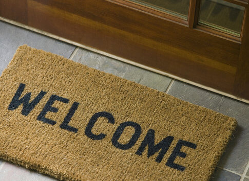 Brown door mat with black lettering reading "Welcome"