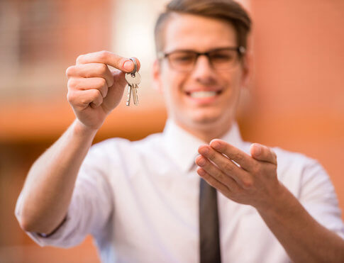 Smiling young apartment landlord, reaching out with apartment keys