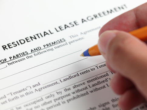 Hand signing apartment lease agreement with pen