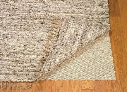 Brown-beige rug with rug pad underneath