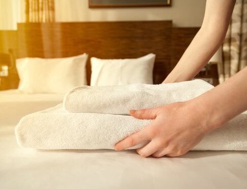 Setting out fresh towels on a crisp white bed