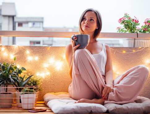 Young adult woman enjoying a quiet moment on her apartment balcony