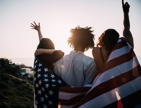 Group of multi-ethnic friends holding U.S. flag and celebrating the Fourth of July