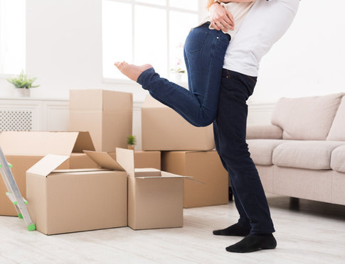 Crop of happy couple hugging near unpacked boxes in new apartment, copy space