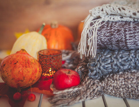 Fall pumpkins, candle votives and cozy blankets for apartment decorating