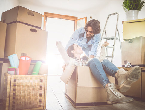 Young hip couple moving into new furnished apartment, playing in boxes