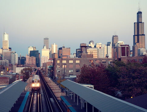 above-ground-train-heading-away-from-chicago-skyline