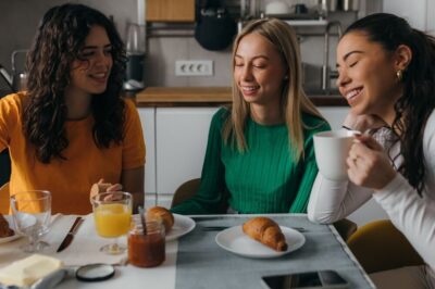 Three female roommates having breakfast together.