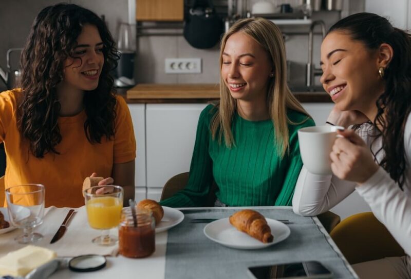 Three female roommates having breakfast together.