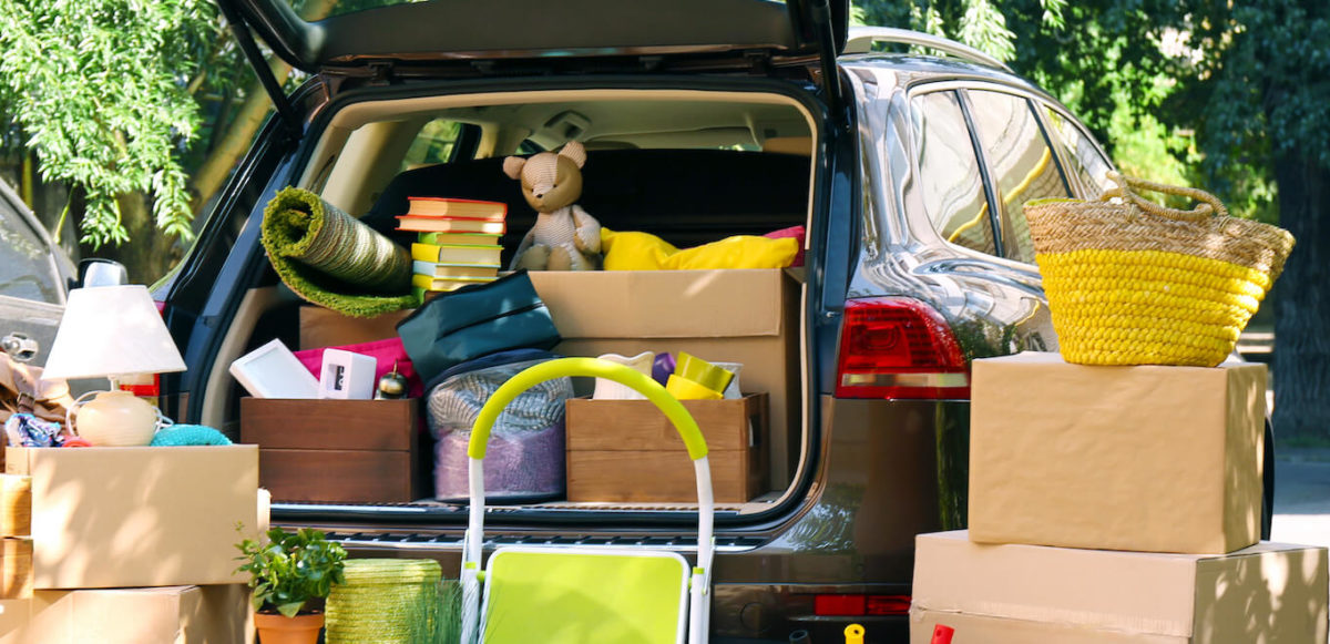 A small hatchback SUV is filled with boxes and a variety of home goods.