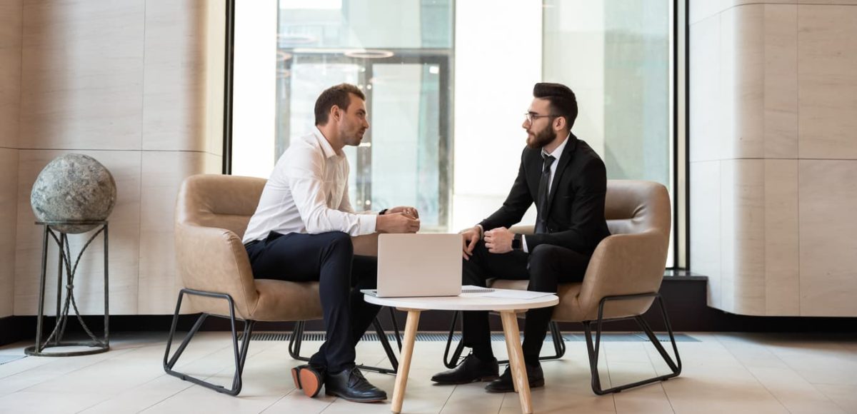 Two men in business attire discussing a deal.