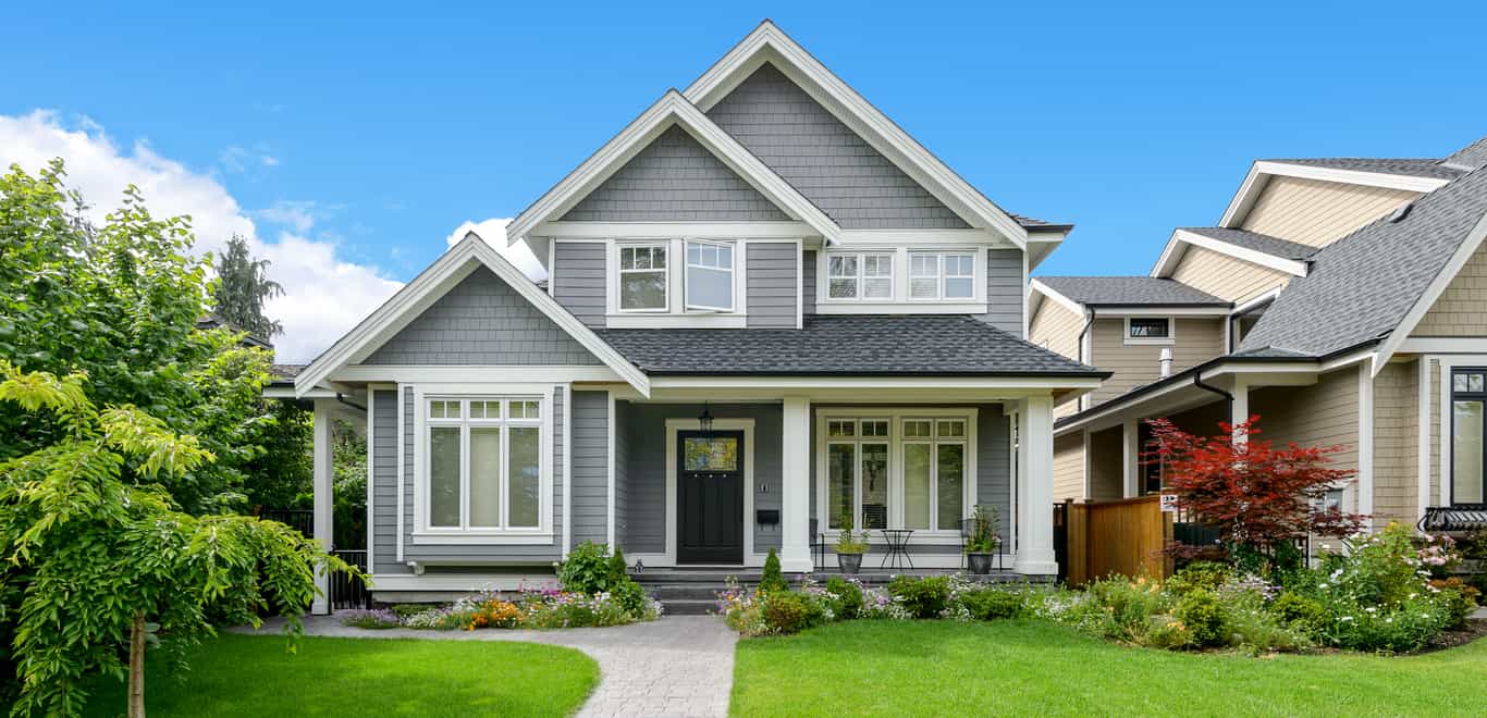 Gray home with white trim in suburban neighborhood.