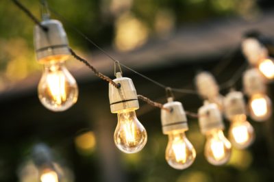 Outdoor string lights hanging on a line in backyard.