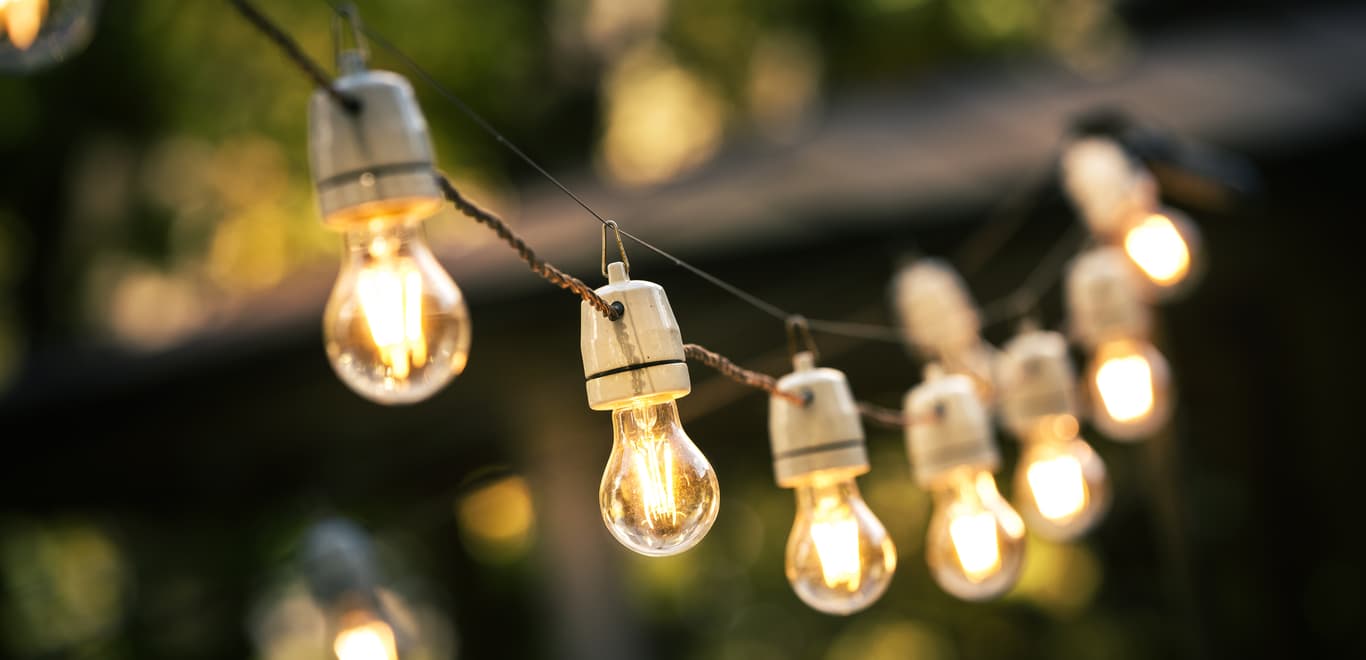 Outdoor string lights hanging on a line in backyard.