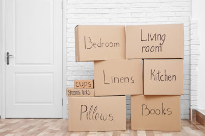 Labeled moving boxes stacked up in an apartment, how many boxes do I need to move?