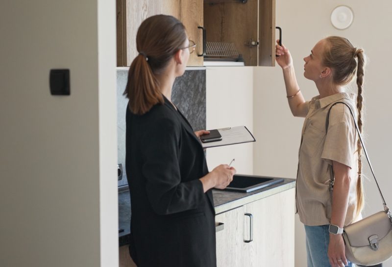 Woman looking at an empty apartment with a leasing agent