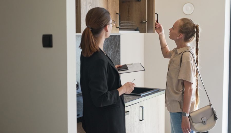 Woman looking at an empty apartment with a leasing agent