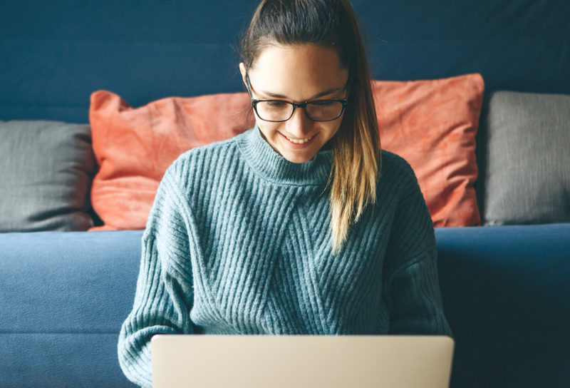 Girl working on laptop from home or student studying from home or freelancer. Or she is watching a video or using the Internet