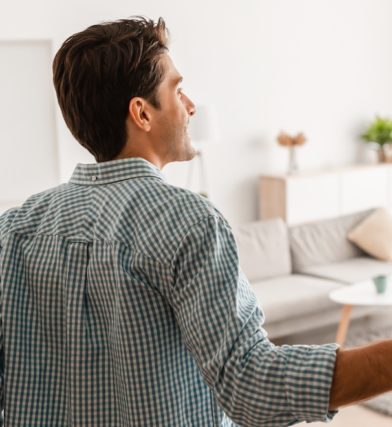 Man finally finds apartment after wondering why it is so hard to find an apartment and now he is smiling and looking in