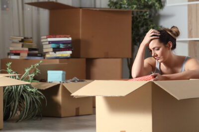 Woman sitting on floor amongst moving boxes