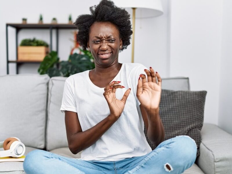 A young woman in her apartment is grossed out by a smell.