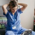 A travel nurse getting ready for the day, fixing her hair.