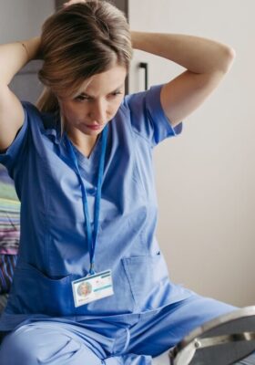 A travel nurse getting ready for the day, fixing her hair.