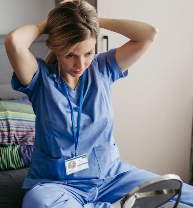 A travel nurse getting ready for the day, fixing her hair.